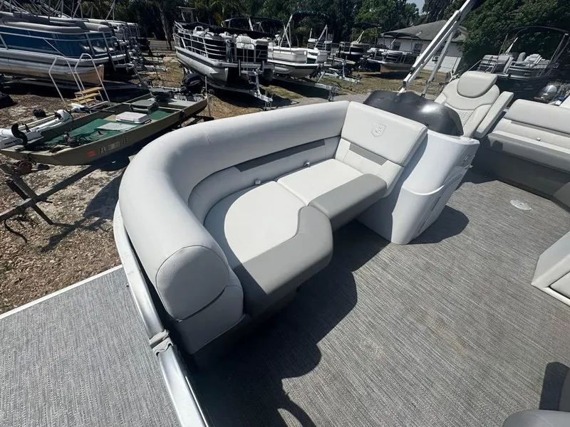 Slide: The Image of Pontoon boat interior with gray seating, Sweetwater 1880 CX, 2021 model, in a marina setting. - 5