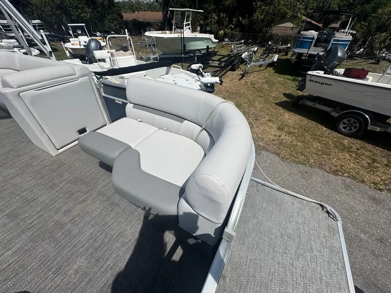 Slide: The Image of Sweetwater 1880 CX 2021 pontoon boat with gray seating, parked outdoors. - 6