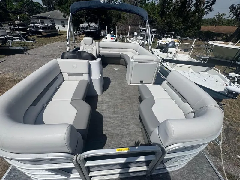 Slide: The Image of 2021 Sweetwater 1880 CX pontoon boat with spacious seating and canopy, parked outdoors. - 7