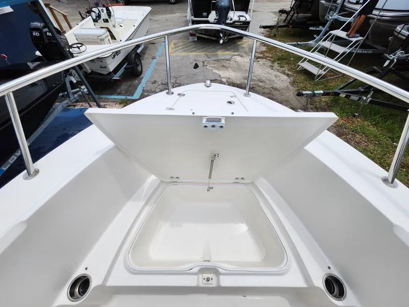 Slide: The Image of 2018 Robalo R180 Center Console boat with open storage compartment on deck. - 25