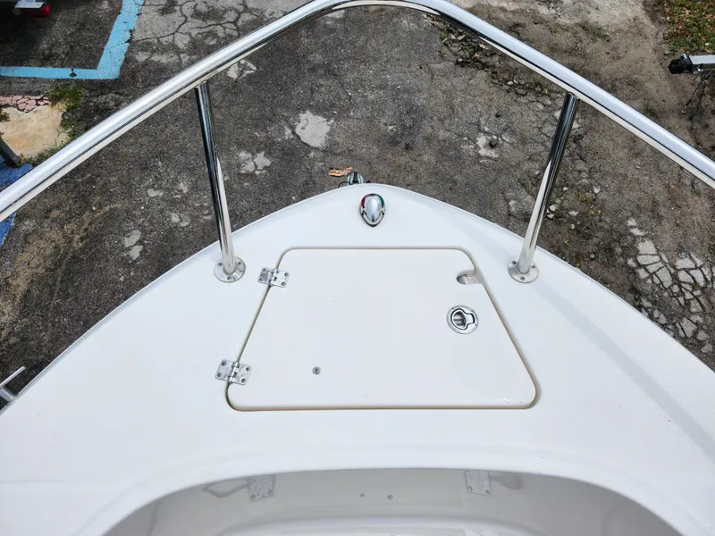 Slide: The Image of 2018 Robalo R180 Center Console boat bow with storage hatch and railing. - 26