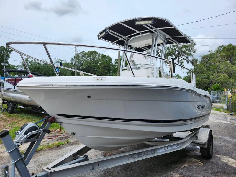 Slide: The Image of 2018 Robalo R180 Center Console boat on trailer, white hull, outdoor setting. - 3