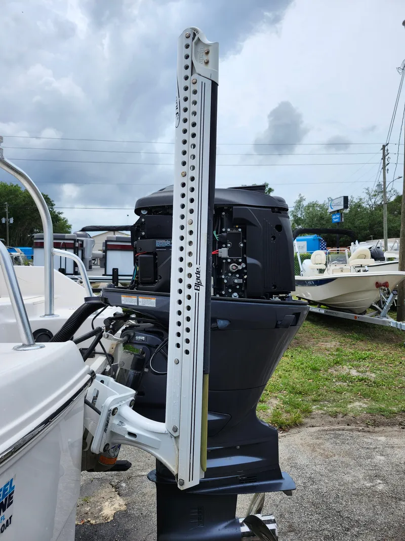 Slide: The Image of 2018 Robalo R180 Center Console boat with outboard motor, parked outdoors under cloudy skies. - 33