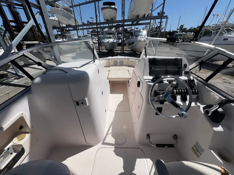 Slide: The Image of 2006 Grady-White Freedom 225 boat interior with steering wheel and dashboard in marina setting. - 6