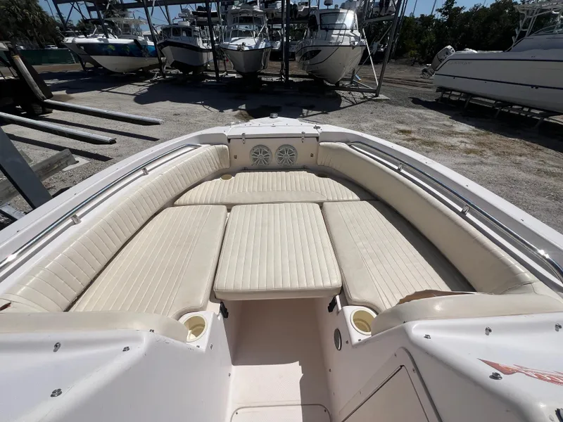 Slide: The Image of 2006 Grady-White Freedom 225 boat interior with cushioned seating in a marina setting. - 8