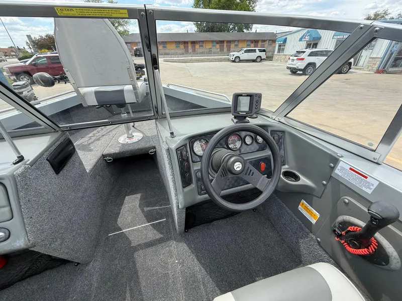 Slide: The Image of 2002 Lund 1800 Fisherman boat interior with steering wheel and dashboard controls. - 6