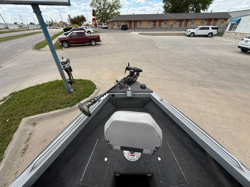 Slide: The Image of 2002 Lund 1800 Fisherman boat parked in a lot, featuring a trolling motor. - 8