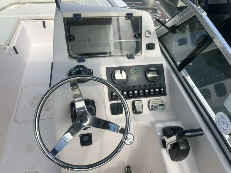 Slide: The Image of 2008 Grady-White 225 Tournament boat dashboard with steering wheel and control panel. - 10
