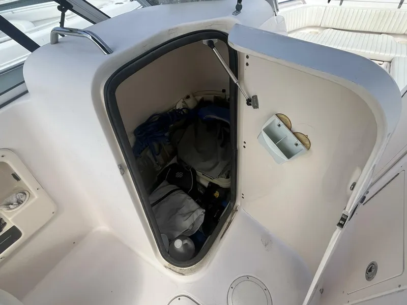 Slide: The Image of Storage compartment on a 2008 Grady-White 225 Tournament boat, partially open with items inside. - 18