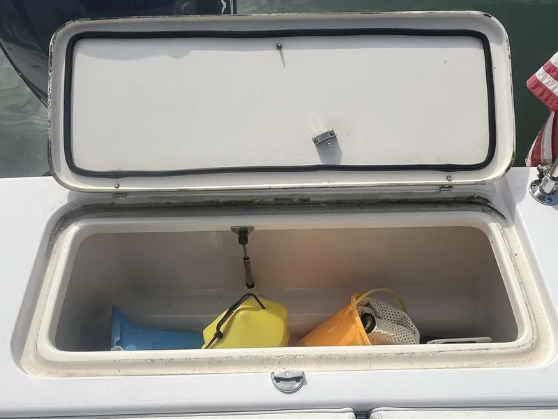 Slide: The Image of Open storage compartment on 2008 Grady-White 225 Tournament boat with various items inside. - 23