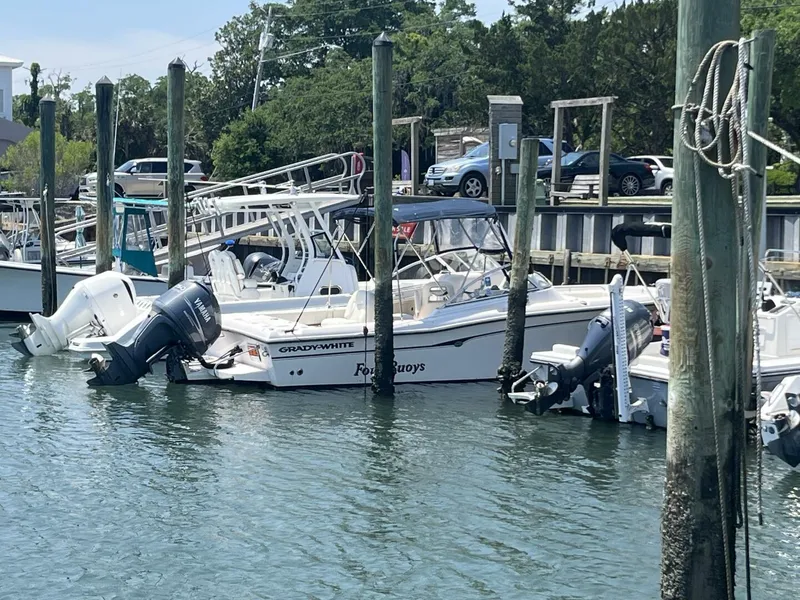 Slide: The Image of 2008 Grady-White 225 Tournament boat docked at a marina with other vessels. - 4
