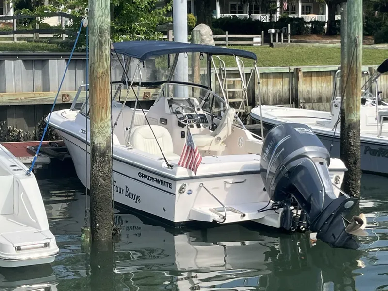 Slide: The Image of 2008 Grady-White 225 Tournament boat docked with outboard motor and American flag. - 5