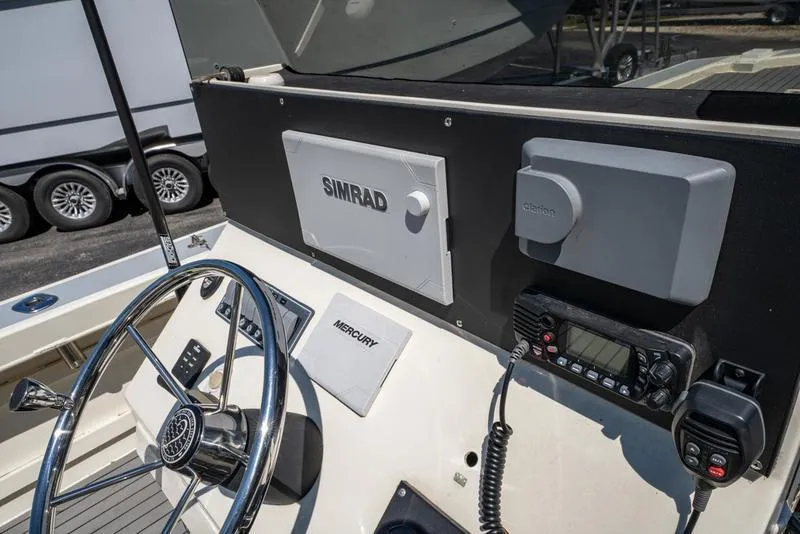 Slide: The Image of Steering console of 2018 Encore Boat Works 25 Custom with Simrad and Mercury equipment. - 12