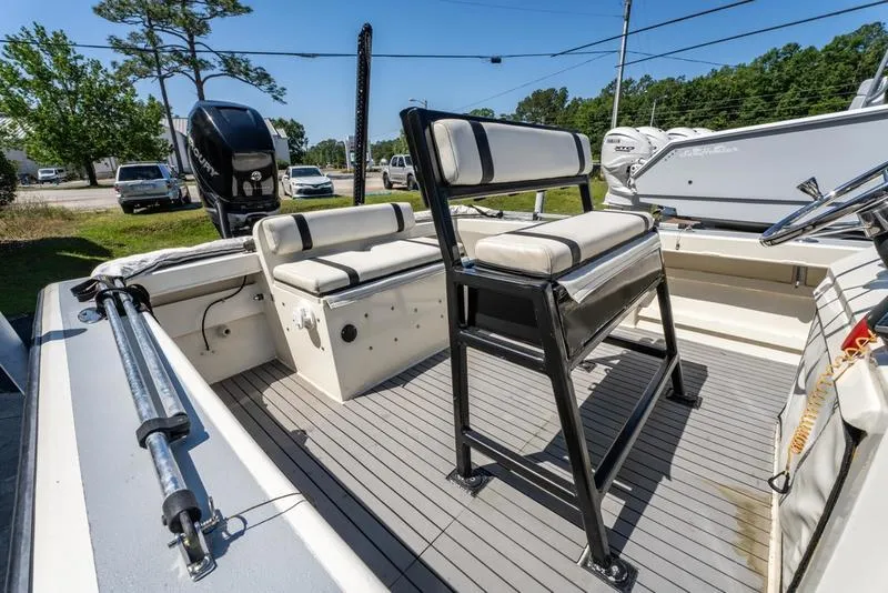 Slide: The Image of 2018 Encore Boat Works 25 Custom with seating and outboard motor, docked outdoors. - 13
