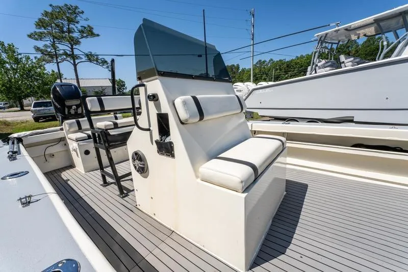 Slide: The Image of 2018 Encore Boat Works 25 Custom with seating and console, docked outdoors. - 15
