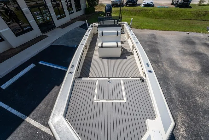 Slide: The Image of 2018 Encore Boat Works 25 Custom, spacious deck, parked outdoors, gray flooring, modern design. - 17
