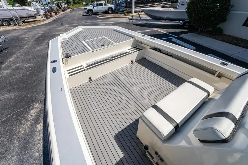 Slide: The Image of 2018 Encore Boat Works 25 Custom with spacious deck and seating, parked outdoors. - 19