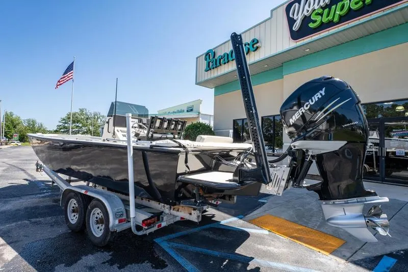 Slide: The Image of 2018 Encore Boat Works 25 Custom on trailer, parked outside a store with American flag. - 3