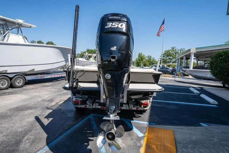 Slide: The Image of 2018 Encore Boat Works 25 Custom with powerful 350 engine, parked outdoors. - 8