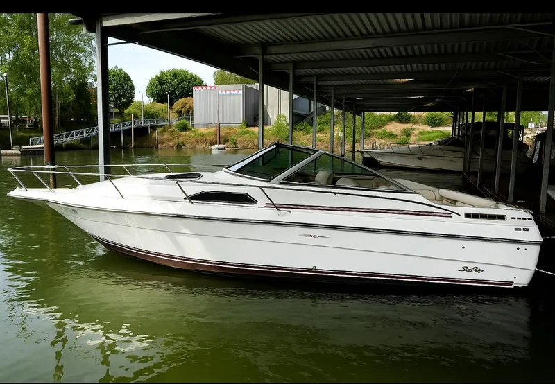 The Image of 1989 Sea Ray Sundancer boat docked in a covered marina. - 0