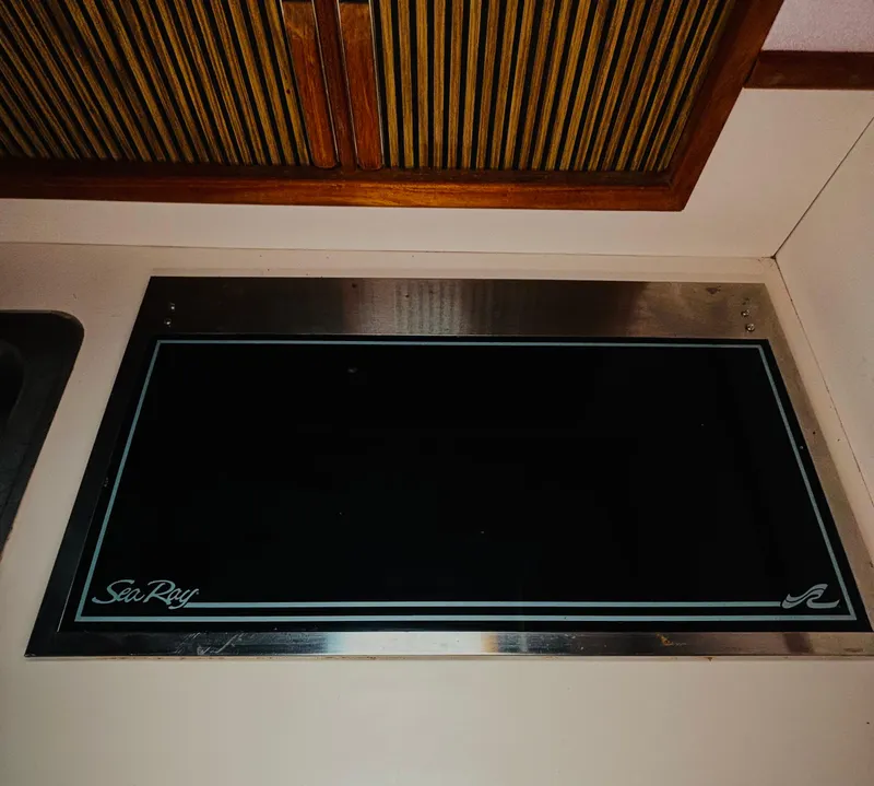 Slide: The Image of 1989 Sea Ray Sundancer interior with sleek black panel and wooden accents. - 13