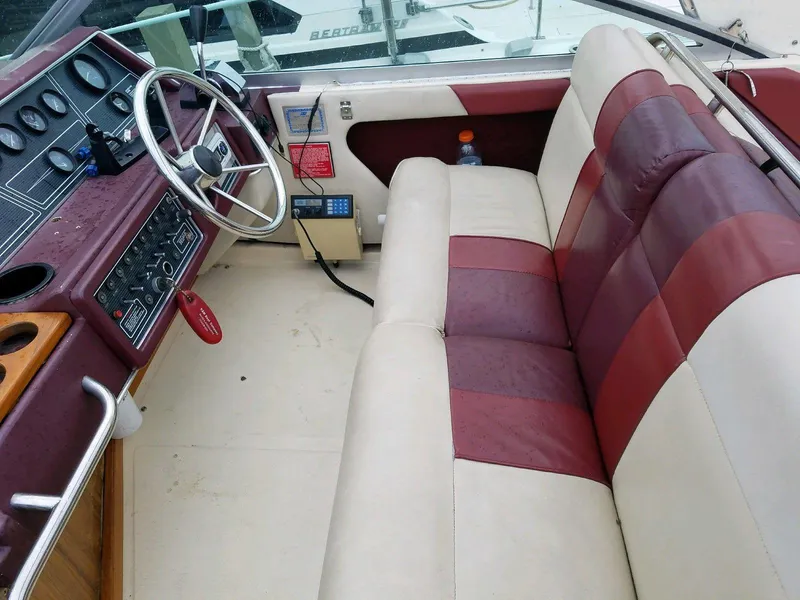 Slide: The Image of 1989 Sea Ray Sundancer cockpit with maroon and cream seating, steering wheel, and control panel. - 2