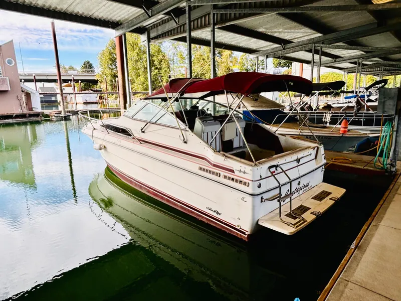 Slide: The Image of 1989 Sea Ray Sundancer boat docked under a covered marina. - 5