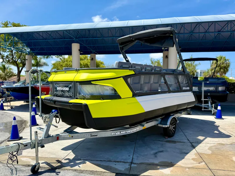 Slide: The Image of 2024 Sea-Doo Switch® Cruise 21 boat on trailer, vibrant yellow and black design, outdoor display. - 2