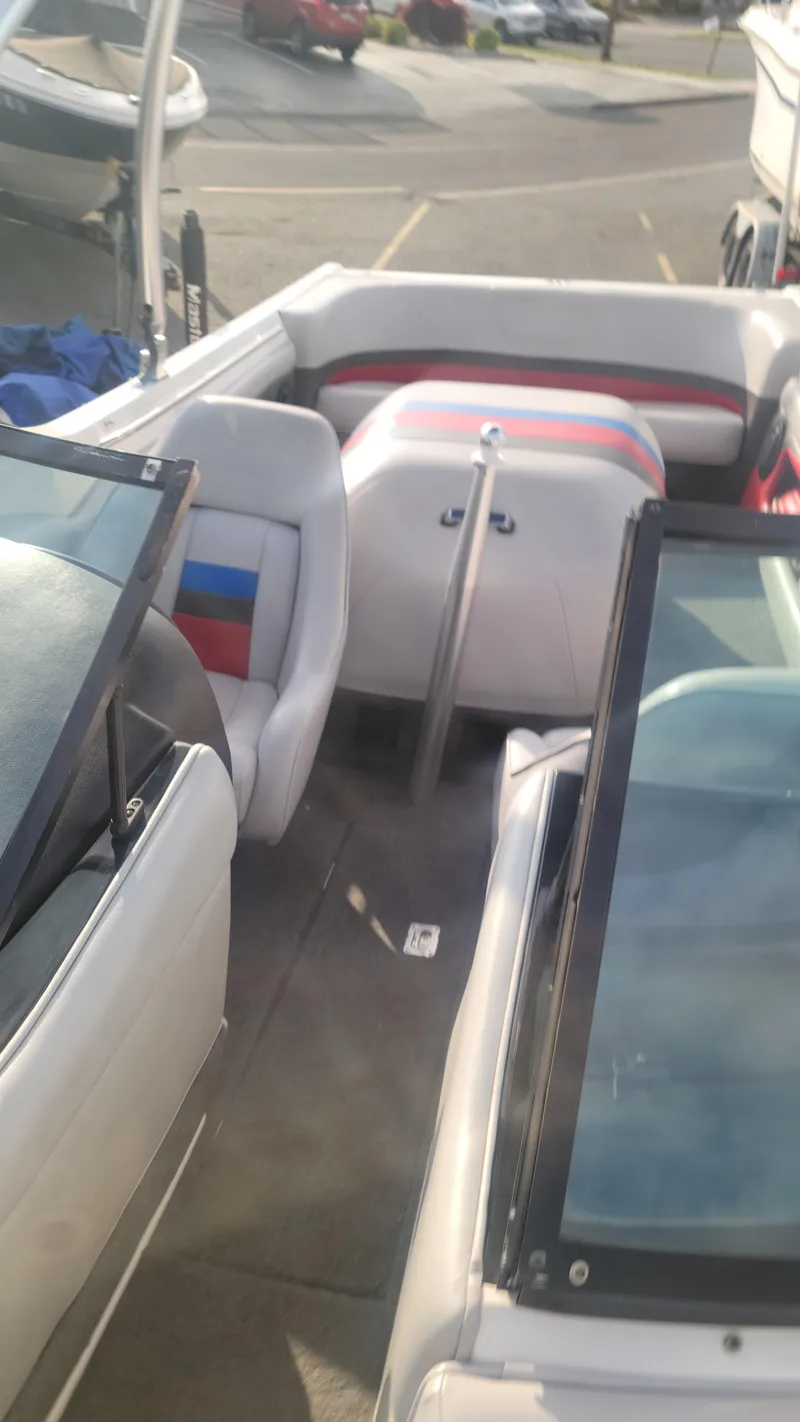 Slide: The Image of 1993 MasterCraft Prosport 205 boat interior with seating and windshield in a parking lot. - 7