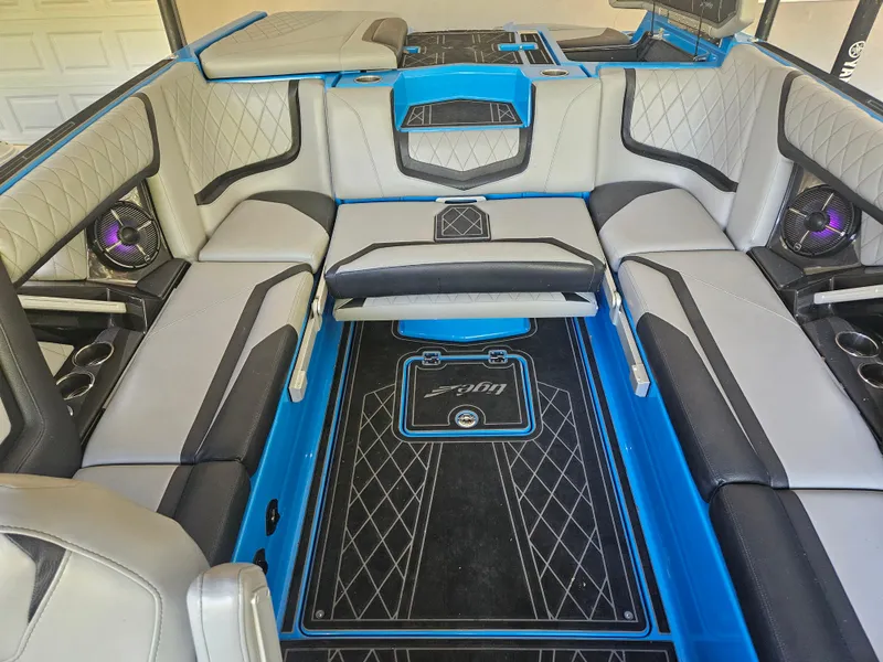 Slide: The Image of 2020 Tigé ZX25 boat interior with gray and black seating, blue accents, and cup holders. - 10