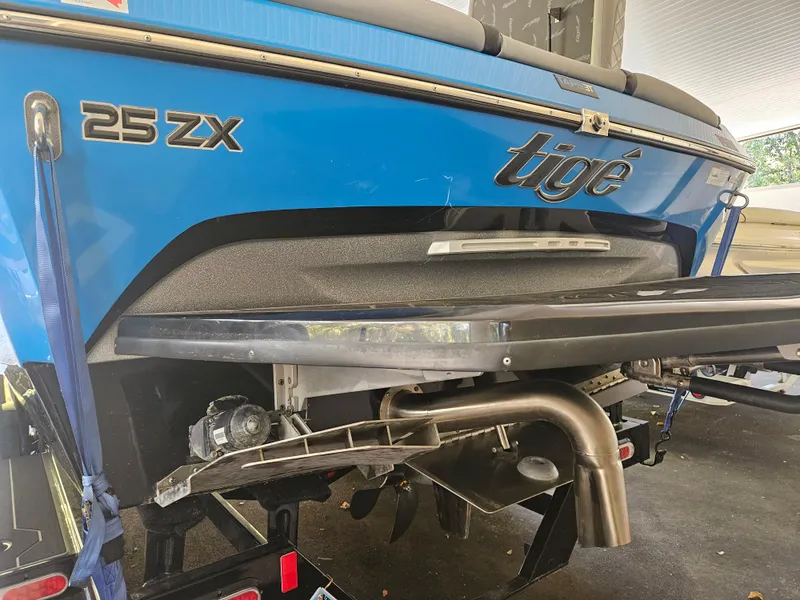 Slide: The Image of 2020 Tigé ZX25 boat rear view, showcasing blue exterior and branding. - 15