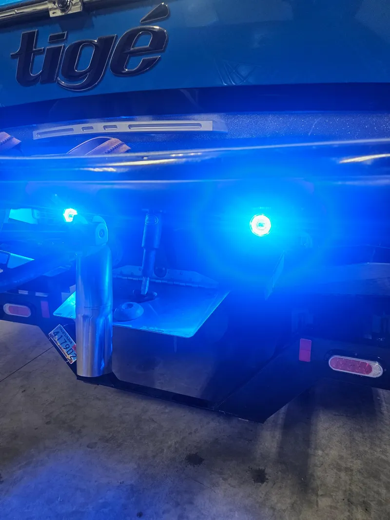 Slide: The Image of 2020 Tigé ZX25 boat with illuminated blue underwater lights at the rear. - 20