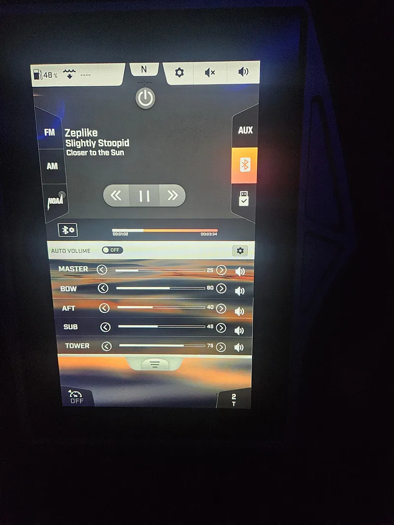 Slide: The Image of Control panel of a 2020 Tigé ZX25 boat displaying audio settings and song information. - 23