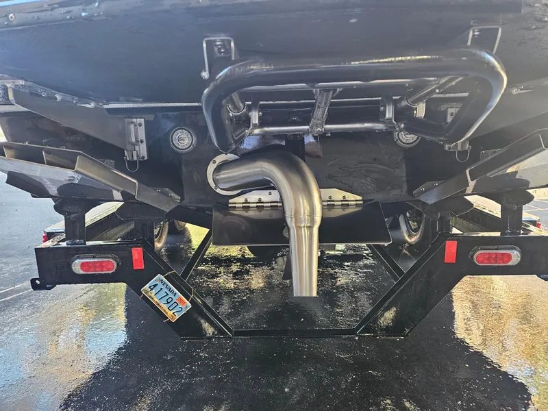 Slide: The Image of Rear view of a 2020 Tigé ZX25 boat on a trailer, showcasing exhaust and hull details. - 3