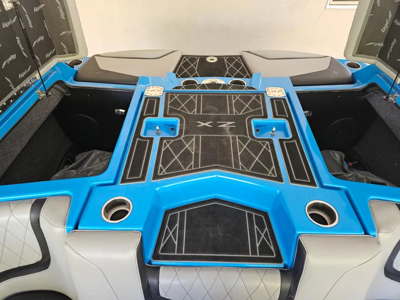 Slide: The Image of 2020 Tigé ZX25 boat interior with blue and black detailing, featuring cup holders and storage compartments. - 9