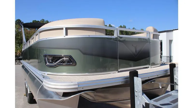Slide: The Image of 2025 Tahoe Sport 85 Rear Fish 23 SW pontoon boat, rear view, parked outdoors. - 4