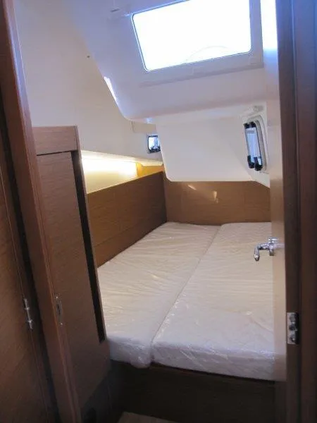 Slide: The Image of 2024 Jeanneau Sun Odyssey 410 cabin interior with twin beds and natural lighting. - 16
