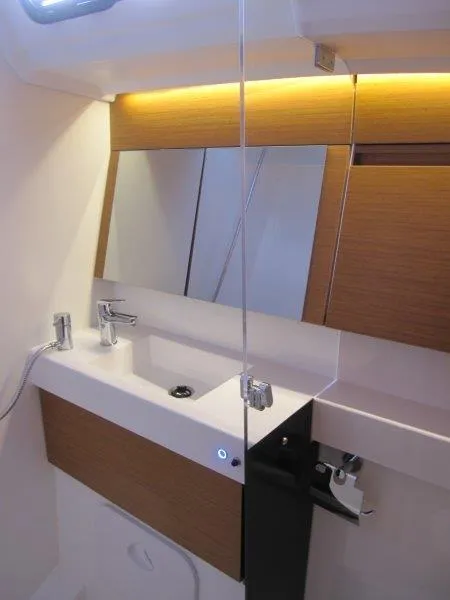 Slide: The Image of Modern bathroom in 2024 Jeanneau Sun Odyssey 410 yacht with sleek fixtures and wood accents. - 18