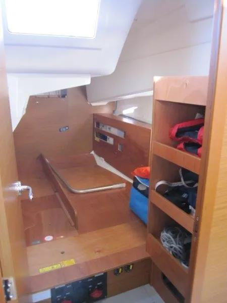 Slide: The Image of 2024 Jeanneau Sun Odyssey 410 cabin interior with wooden storage and seating area. - 19
