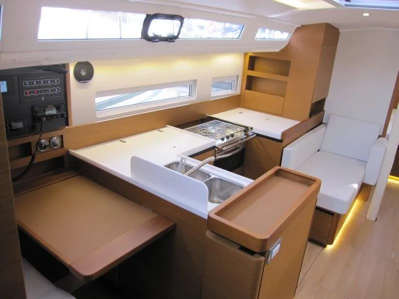 Slide: The Image of 2024 Jeanneau Sun Odyssey 410 interior with modern kitchen and seating area. - 2