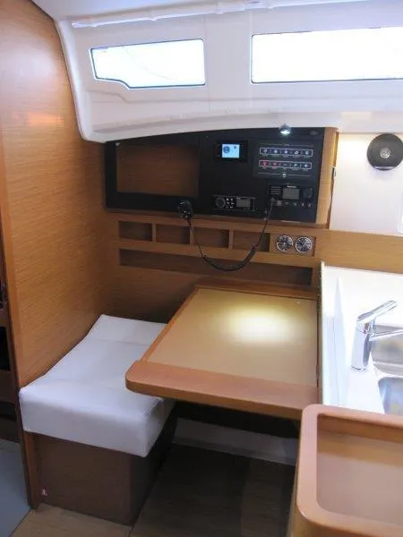 Slide: The Image of 2024 Jeanneau Sun Odyssey 410 interior with navigation station and seating area. - 3