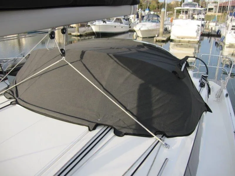 Slide: The Image of 2024 Jeanneau Sun Odyssey 410 sailboat with protective cover in marina setting. - 31