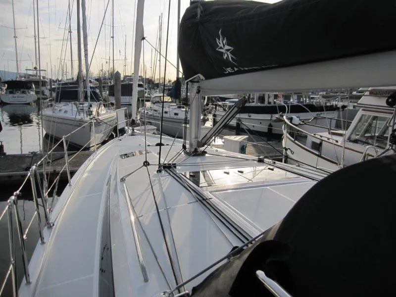 Slide: The Image of 2024 Jeanneau Sun Odyssey 410 sailboat docked in a marina, showcasing sleek deck design. - 39