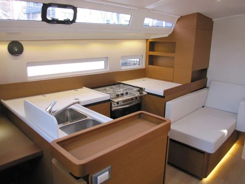 Slide: The Image of 2024 Jeanneau Sun Odyssey 410 interior with modern kitchen and seating area. - 4