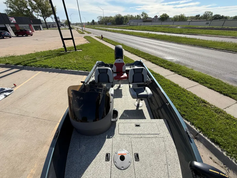 Slide: The Image of 2012 Crestliner Kodiak 16 boat parked on a sunny street, showcasing interior seating and controls. - 10