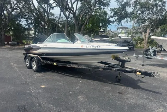 Slide: The Image of 2002 Triton 190-FS boat on trailer in outdoor setting with trees. - 0