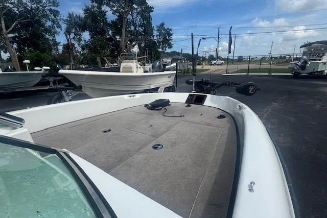 Slide: The Image of 2002 Triton 190-FS boat with spacious deck, parked outdoors under a clear sky. - 10
