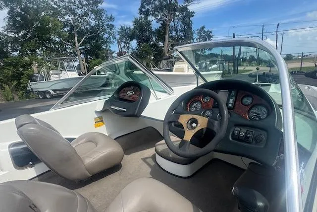 Slide: The Image of 2002 Triton 190-FS boat interior with steering wheel and dashboard, featuring comfortable seating. - 11