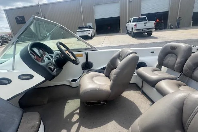 Slide: The Image of Interior of a 2002 Triton 190-FS boat with beige seating and dashboard. - 13