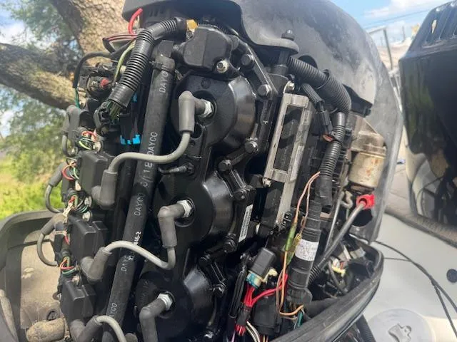 Slide: The Image of 2002 Triton 190-FS boat engine with exposed wiring and components. - 19